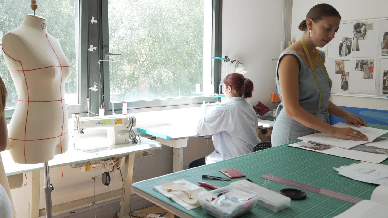Maathi atelier in Paris with designers and patternmakers refining garment prototypes by hand, illustrating artisanal craftsmanship and slow fashion practices.