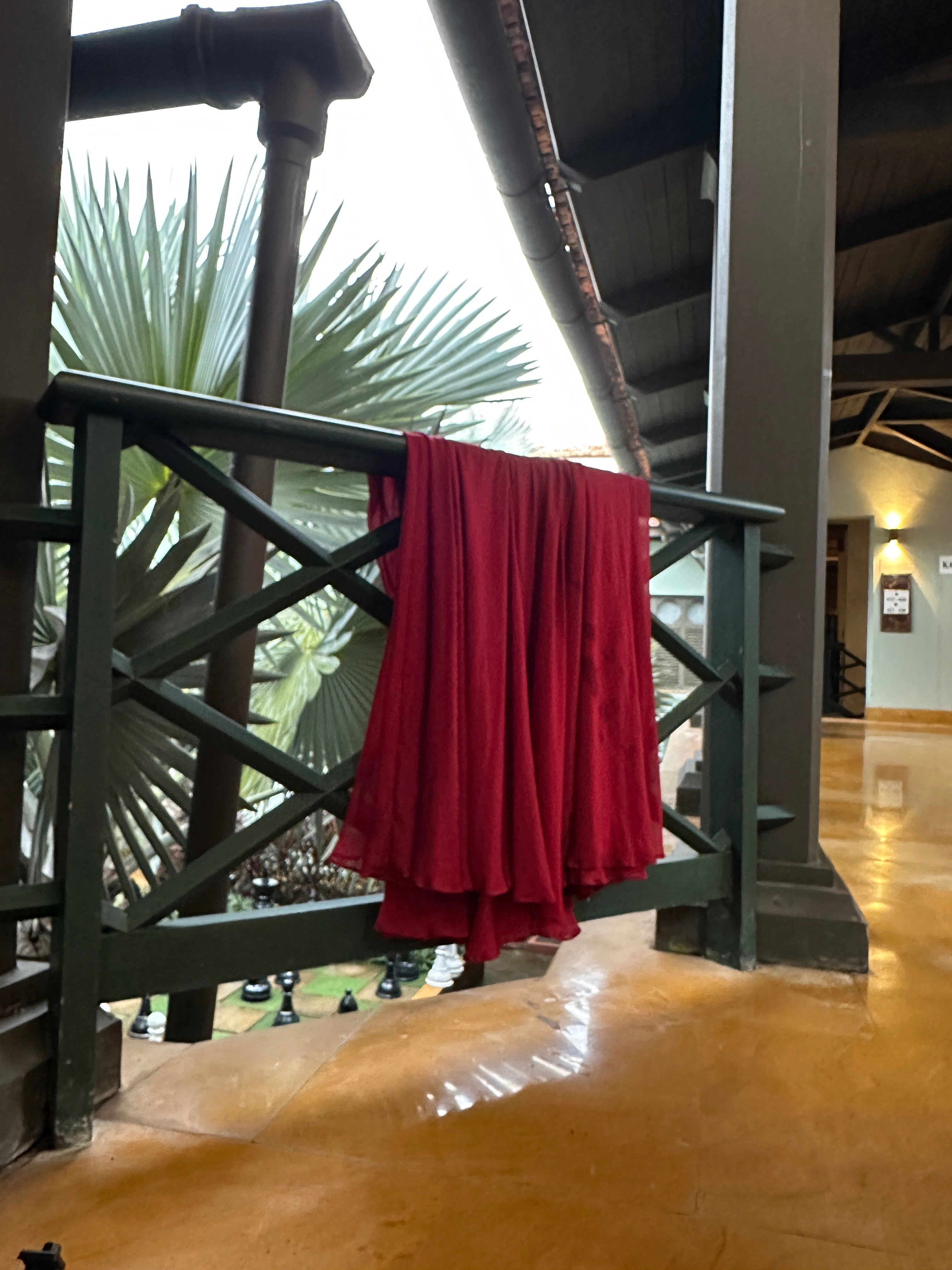 Red fabric draped over a railing, resting in natural light.